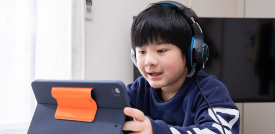 ヘッドホンをしてゲームをする子ども